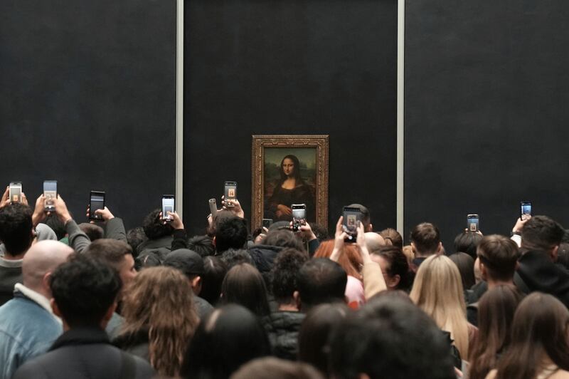 The Mona Lisa is displayed behind protective glass in a room that is often overcrowded by large, noisy queues of visitors Photograph: AP