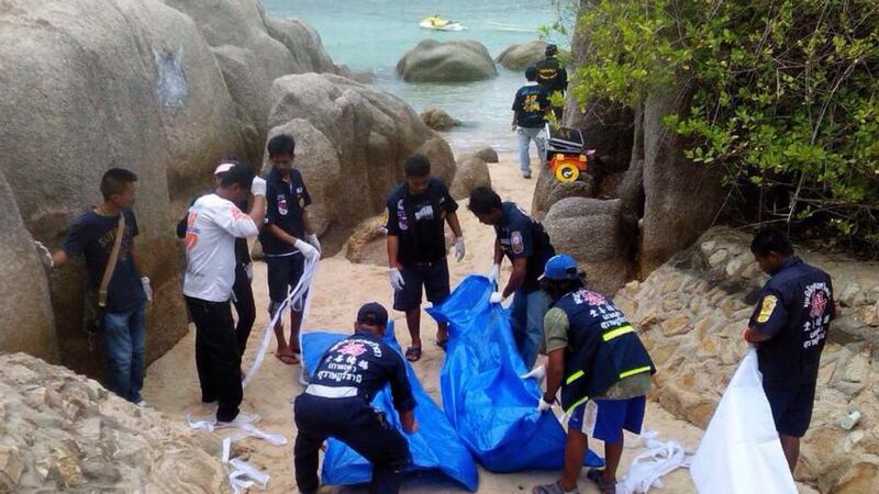 Thai rescue workers wrap the bodies of two British tourists who were found dead on a beach of Koh Tao island. Photograph: EPA