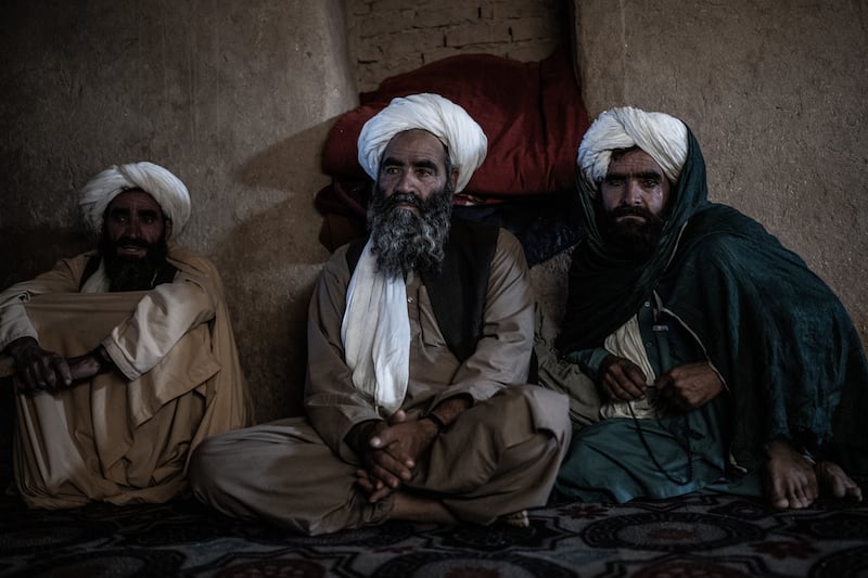 Haji Hawaladar, center, with fellow farmers, at his home in southwest Afghanistan’s arid Bakwa district on April 23rd, 2023. For nearly 15 years, poppies grown in Bakwa - and the taxes the Taliban collected from it - supported the insurgents. Now the narcotic crop is banned again. “We have no choice but to stick it out,” said Hawaladar, who had moved his entire family to Bakwa. Photograph: Bryan Denton/The New York Times
                      