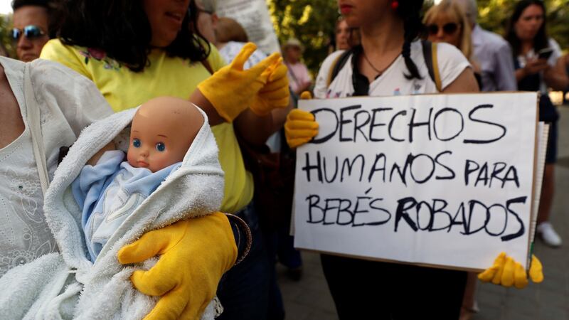 A protester holds a placard reading, “Humans rights for stolen babies” outside the Madrid court on Tuesday where a doctor went on trial on charges of child abduction and falsification of documents. Photograph: Chema Moya/EPA