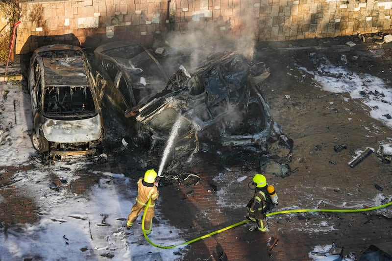 Israeli firefighters extinguish fire after a rocket fired from the Gaza Strip hit a parking lot in Ashkelon, southern Israel. Photograph: Tsafrir Abayov/AP