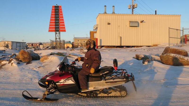 Snowmobiles head out “on to the land” across the icy Frobisher Bay. Photographs: Rosie Gogan-Keogh/Getty