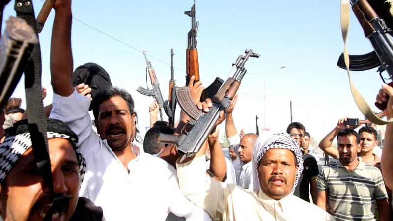 Iraqi volunteers to fight with Iraqi forces carry their weapons and chant slogans in Karbala city, southern Baghdad today. Photograph: Alaa Al-Shemaree/EPA