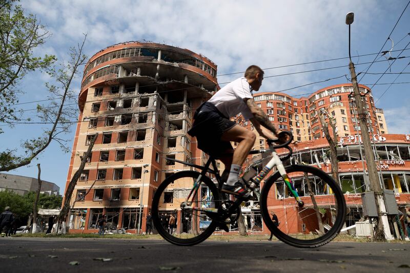 A man cycles past a commercial building damaged in an overnight Russian strike in Odesa. Photograph: Oleksandr Gimanov/ AFP