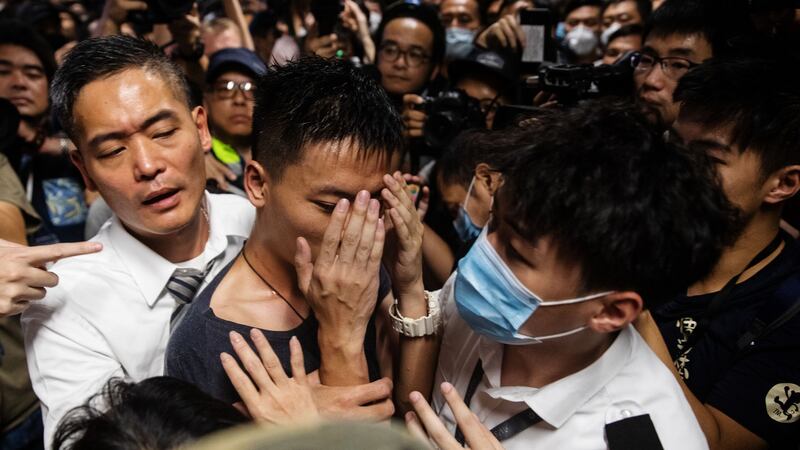 A man alleged to be a mainland police officer is surrounded by security officials and protesters at the Hong Kong International Airport in Hong Kong, China.  Photograph: Kyle Lam/Bloomberg