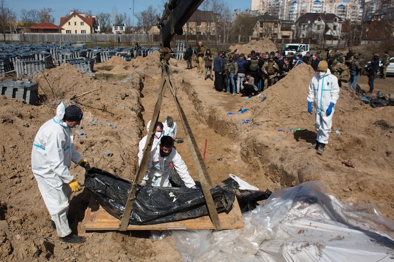 Members of an exhumation team work on a mass grave in Bucha, Ukraine. Photograph: Anastasia Vlasova/Getty Images