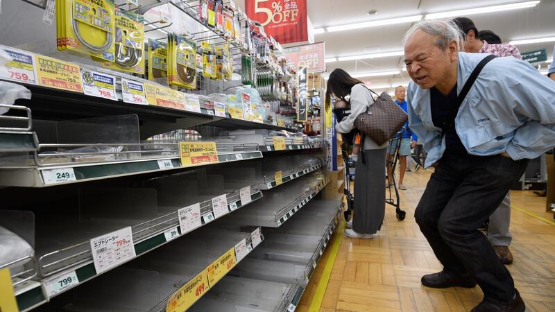 A customer looks at empty shelves as he shops for waterproof products in preparation for Typhoon Hagibis. Photo: Akio Kon/Bloomberg