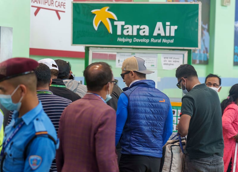 A sign for Tara Air is seen as a team of climbers prepares to leave for a rescue operation from Tribhuvan International Airport in Kathmandu, Nepal (Niranjan Shreshta/AP)