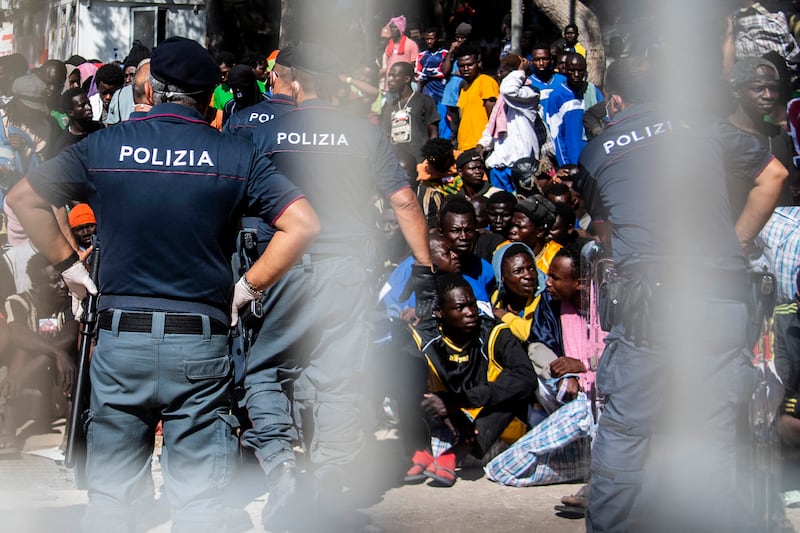 Migrants gather outside the operational center called "Hotspot" on the Italian island of Lampedusa. Photograph: Alessandro Serranò/AFP via Getty Images