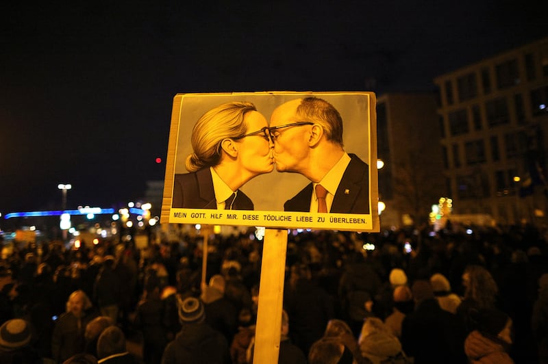 A banner with an AI image depicting AfD co-chairwoman Alice Weidel and CDU leader of Friedrich Merz is held up during a protest outside the CDU headquarters in Berlin on Sunday. Photograph: Omer Messinger/Getty Images