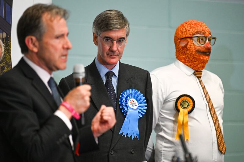 Conservative candidate Jacob Rees-Mogg stands next to Barmy Brunch from The Official Monster Raving Loony Party as Labour candidate Dan Norris speaks during the declaration for the North East Somerset constituency. Photograph:  Finnbarr Webster/Getty Images