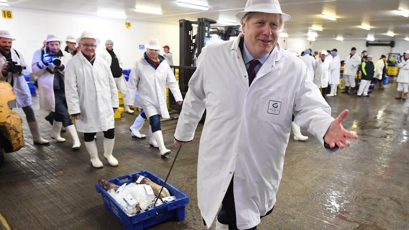 Prime minister Boris Johnson drags a crate of fish during a visit to Grimsby Fish Market, while on the general election campaign trail. Photograph: Stefan Rousseau/PA Wire