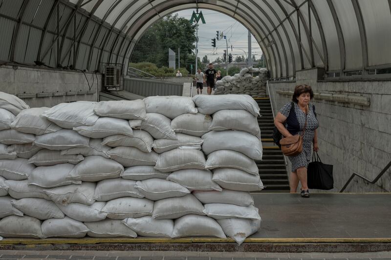 Commuters walk past sandbags at the entrance to a metro station in Kyiv on Sunday. Photograph: Emile Ducke/New York Times