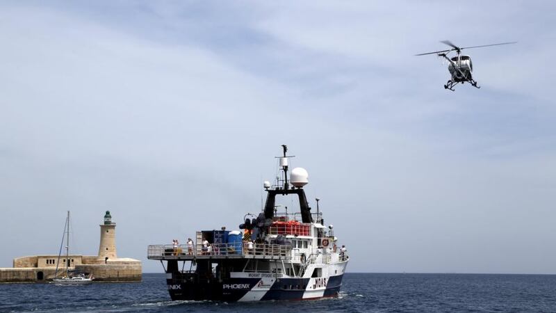 A helicopter flies overhead as the Migrant Offshore Aid Station (MOAS) ship MV Phoenix sails out of Valletta’s Grand Harbour, Malta on Saturday. Photograph: Reuters