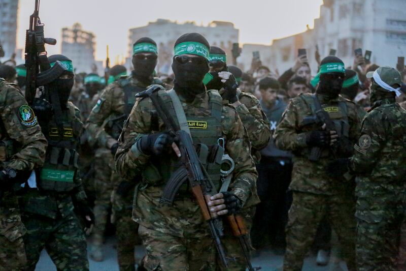 Hamas fighters escort a Red Cross vehicle in Gaza City to collect Israeli hostages released on Sunday after the ceasefire agreement between Israel and Hamas took effect. Photograph: Abood Abusalama/Middle East Images/AFP via Getty Images