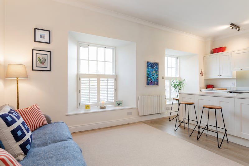 The living/kitchen area has large sash windows and tall ceilings