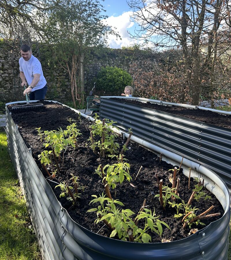 Peter O'Mahony at work in the garden with his child