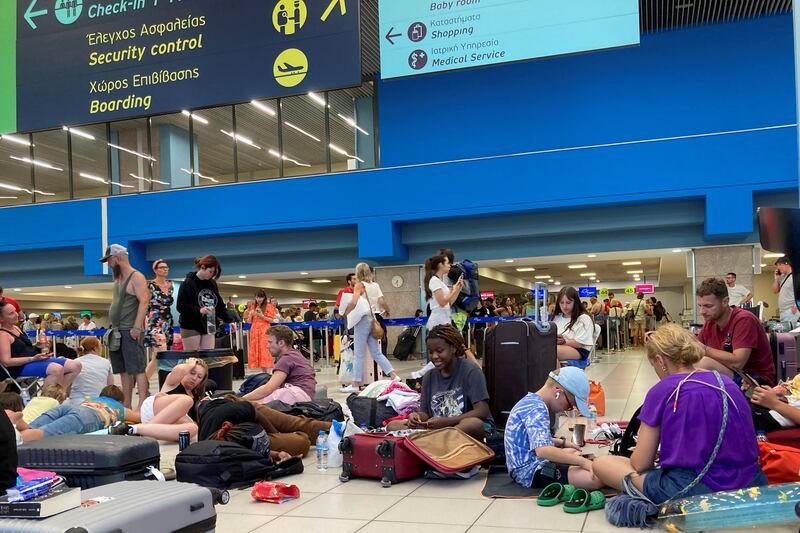 Tourists wait in the airport's departure hall on Sunday night as evacuations are under way due to wildfires on the Greek island of Rhodes. Photograph: Will Vassilopoulos/AFP via Getty