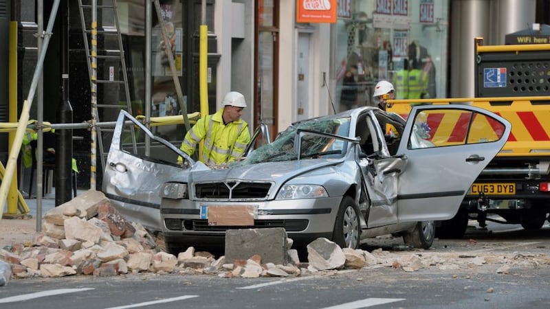 Workmen clear debris at the scene in Kingsway, opposite Holborn Tube station in central London, after  Julie Sillitoe (49), was killed when large chunks of masonry fell from the building above the Hiba restaurant on to her taxi on Friday night.  Photograph: Anthony Devlin/PA Wire