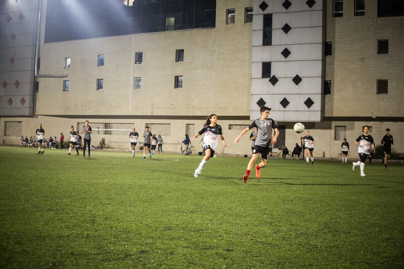 A chase for possession in the friendly match between Sareyet Ramallah and a men's selection of the Football Stars Academy of Rammalh at The Friends Stadium in Al Bireh. Al Bireh, Palestine. Photograph: Giacomo Sini