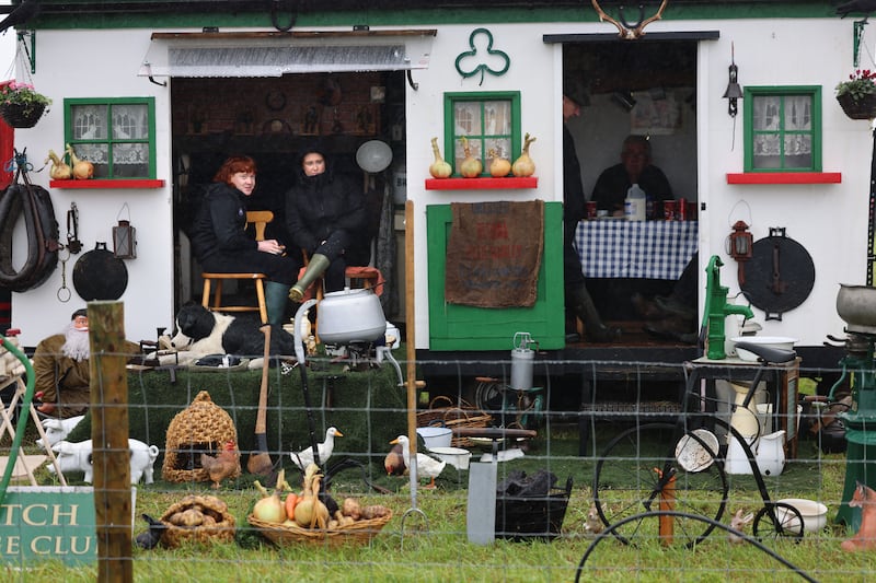 Exhibitors at the event take shelter from the weather. Photograph: Dara Mac Dónaill/The Irish Times