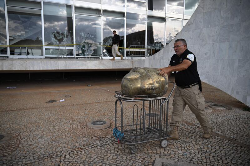 A police officer carries away part of a vandalised sculpture at the supreme court building in Brasília on January 10th, 2023, two days after thousands of supporters of Jair Bolsonaro raided federal buildings. Photograph: Carl de Souza/AFP