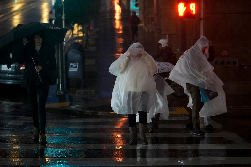 People wearing rain ponchos walk across Kearny Street in San Francisco on Thursday. Photograph: Godofredo A Vasquez/AP