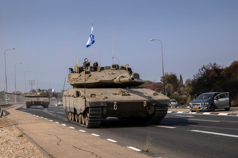 An Israeli tank passes through an area that Hamas gunmen had attacked as it drives towards the border with Gaza in Sderot, Israel, on Sunday. Photograph: Tamir Kalifa/The New York Times
                      