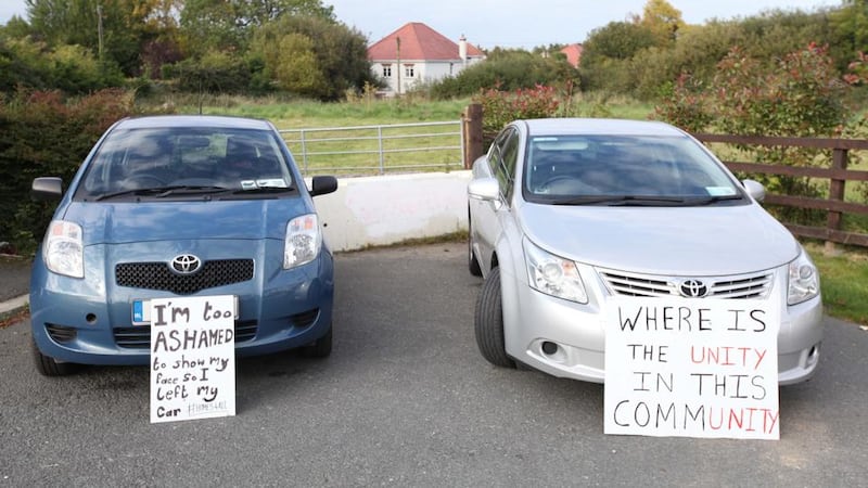 Protest: locals parked cars to block the six-month halting site proposed for Rockville Drive in Carrickmines; the placards were left by counterprotesters. Photograph: Stephen Collins/Collins