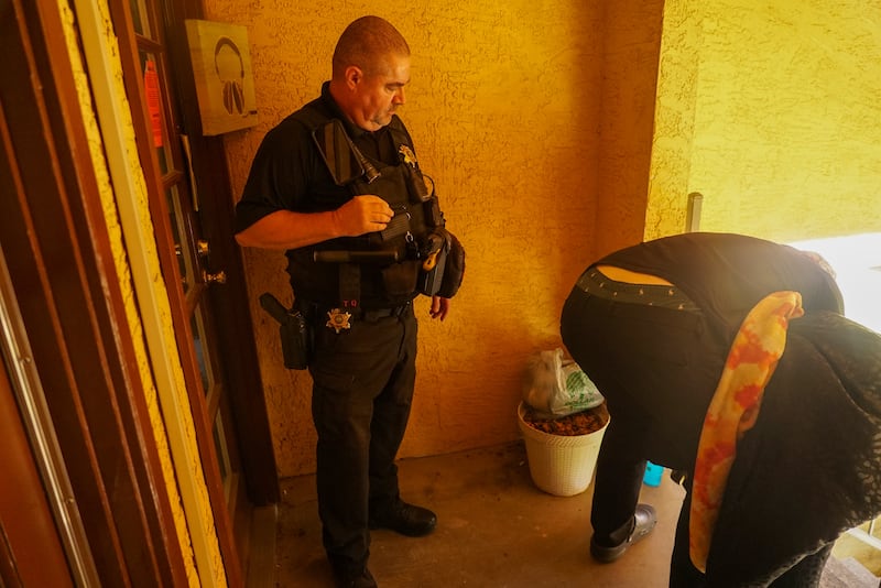 Constable Scott Blake watches on as a man gathers belongings after being told his friend's apartment must be vacated. Photograph: Enda O'Dowd