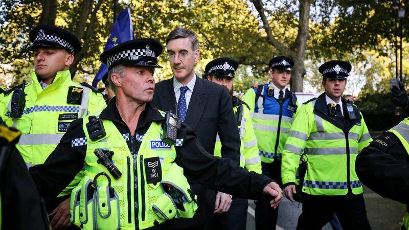 Leader of the House of Commons Jacob Rees-Mogg and his son are escorted by police officers  during an anti-Brexit rally. Photograph: Jacob King/PA Wire