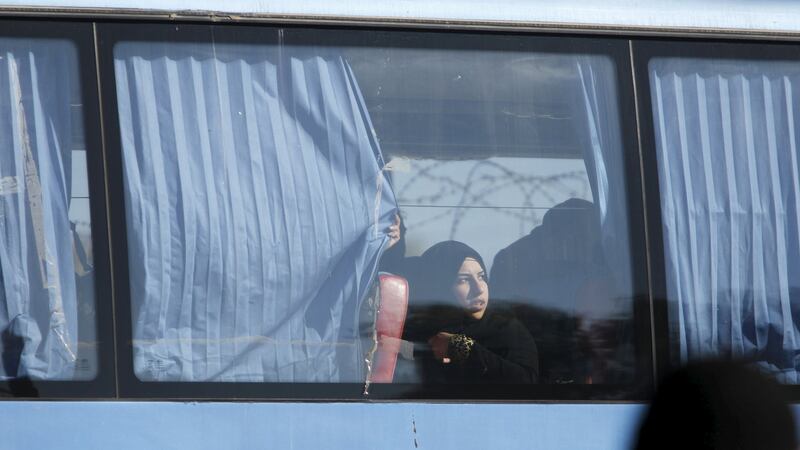 A woman looks out of the window in a bus as she leaves district of Waer in Homs on Wednesday. Photograph: Omar Sanadiki/Reuters