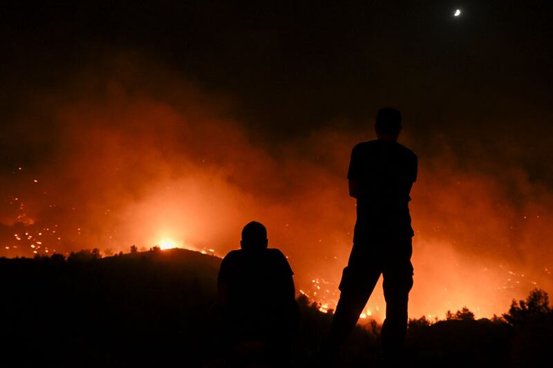 People watch the wildfires near the village of Malona in the Greek island of Rhodes on Sunday night. Photograph: Spyros Bakalis/AFP via Getty