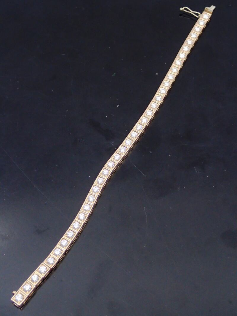 A diamond line bracelet set in 18ct yellow gold, containing 37 diamonds, total estimated weight of diamonds 3cts to 3.5cts, the catch bears a mark of Cartier €4,000-€6,000. 