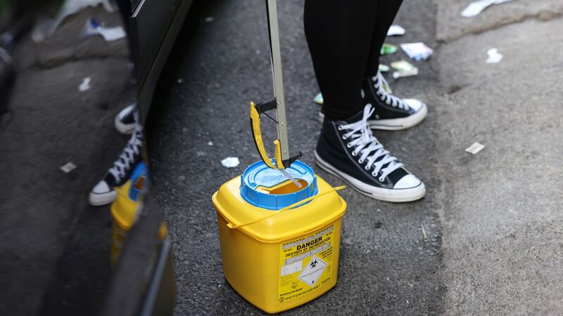 An outreach worker collects used syringes and needles in Dublin city centre on Wednesday morning. Photograph: Dara Mac Dónaill/The Irish Times