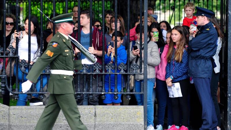 Tourists watch a member of the 7th Infantry Battalion pictured at the Defence Forces Military Changing of the Guard Ceremony at the Defence Forces national memorial in Merrion Square Park Dublin. Photograph: Aidan Crawley