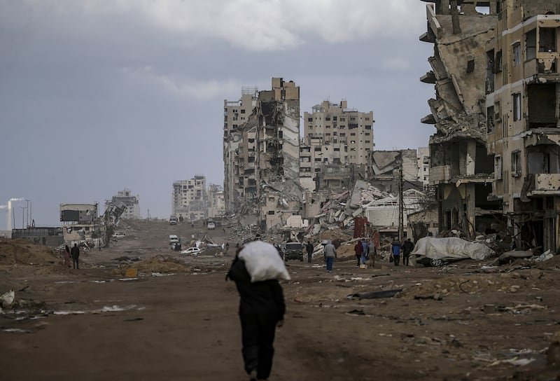 A Palestinian man walks past destroyed buildings in the streets of Gaza City. Photograph:  Mohammed Saber/EPA
