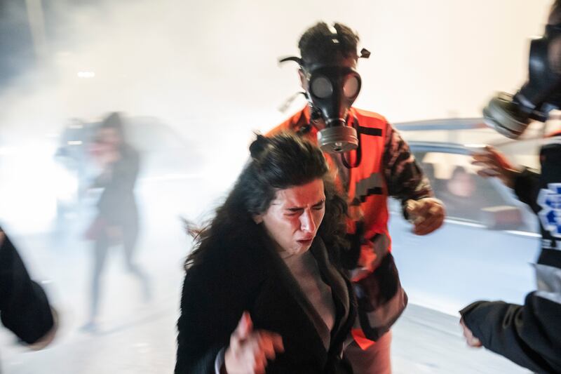 A member of a medical support team assists a woman after Israeli security forces fired tear gas into a crowd of relatives and supporters gathered to welcome Palestinian prisoners and detainees freed as part of the hostage-release deal, near Ramallah in the West Bank, on Friday night. Photograph: Daniel Berehulak/New York Times                  