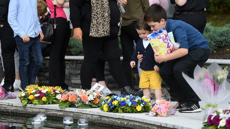 Children leave flowers during a memorial event marking the 20th-anniversary of the Omagh bombing, at the Memorial Garden in Omagh. Photograph: Clodagh Kilcoyne/Reuters