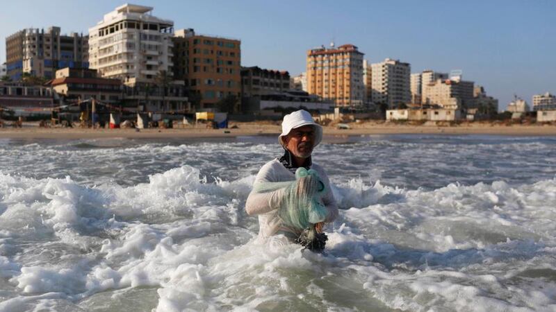 A fisherman prepares to cast his net in Gaza City’s main beachfront today. A Palestinian negotiator says his team will leave Egyptian-brokered talks on ending the Gaza war unless Israeli negotiators return to Cairo. Photograph: Reuters