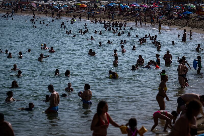 People cool off at a beach in Barcelona as temperatures top 40 degrees. Photograph: Emilio Morenatti/AP