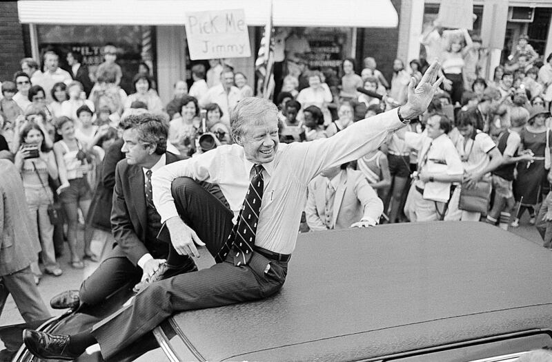 President Jimmy Carter waves from the roof of his car along the parade route through Bardstown, Kentucky. Photograph: Bob Daugherty/AP