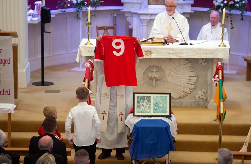 Teddy McCarthy's Cork jersey is brought to the altar by his grandchildren during his funeral at St Joseph’s Church, Springhill, Glanmire, Co Cork, on Saturday. Photograph: Michael Mac Sweeney/Provision