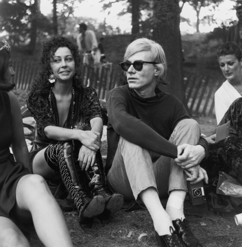 September 1968:  Andy Warhol and Ultra Violet, a member of Warhol's Factory Superstars, sitting with people in Central Park, New York.  Photograph: Tim Boxer/Hulton Archive/Getty 