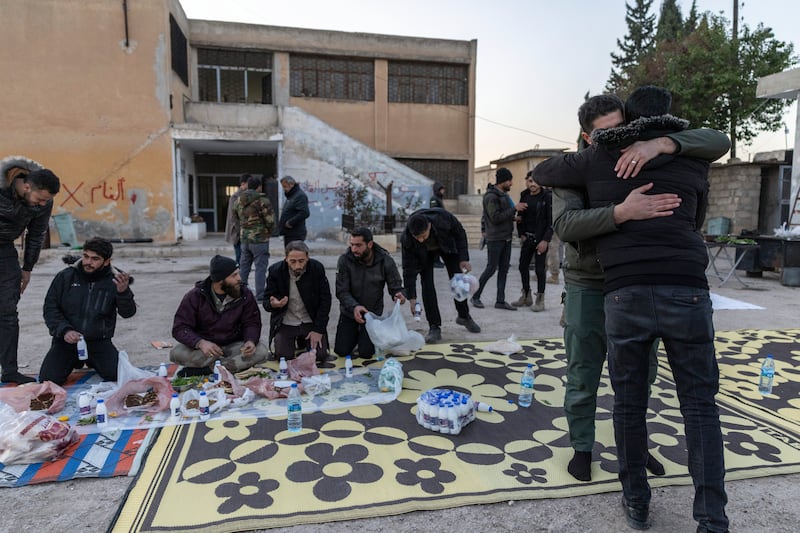  Fighters for the Syrian National Army eat together and greet one another inside a makeshift military base in Tel Rifaat, Syria on Friday, Dec. 13, 2024. (David Guttenfelder/The New York Times) 