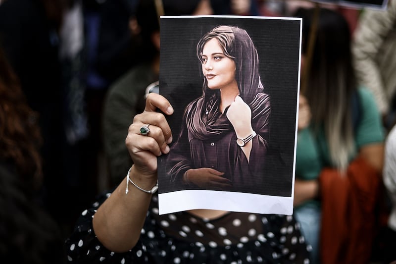 A protester holds a portrait of Mahsa Amini during a demonstration in front of the Iranian embassy in Brussels on September 23rd. Photograph:  Kenzo Tribouillard/AFP via Getty Images