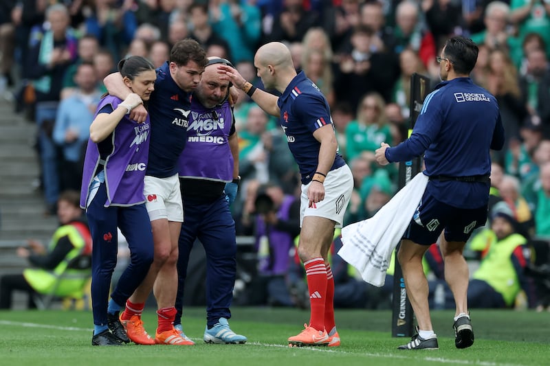 French captain Antoine Dupont is helped off the field after picking up a knee injury in the first half. Photograph: David Rogers/Getty Images