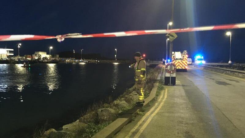 Howth harbour, where a car has fallen into the water. Emergency services are at the scene