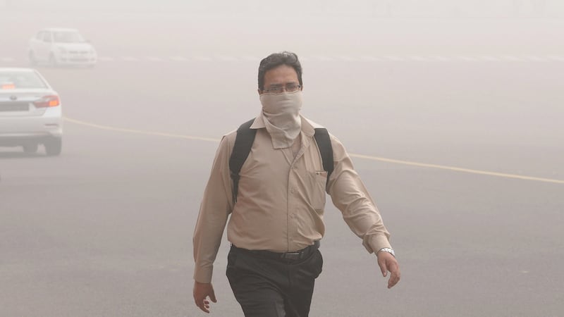 An Inidan man with his face covered walks at Rajpath Avenue engulfed in smog near the Indian president’s house, in New Delhi. Photograph: EPA