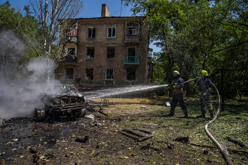 Firefighters hose down a burning car after a Russian strike hit a residential area in Kramatorsk, Donetsk. Photograph: Nariman El-Mofty/AP